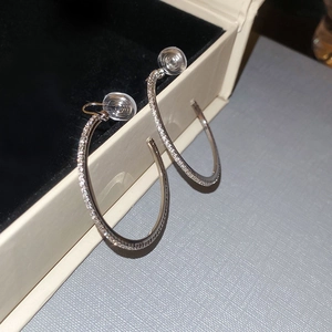 Macro detail of silver sparkling rhinestone hoop earrings on velvet jewelry box padding