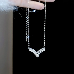 Detail of V-shaped pearl necklace with sparkling rhinestones and adjustable silver chain