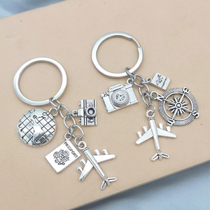 Travel theme keychains with camera, globe, and airplane charms in silver metal finish