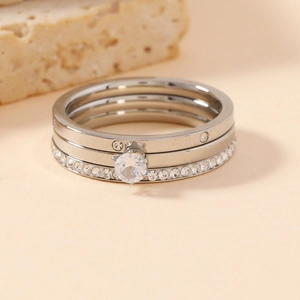 Detailed close-up of a three-piece silver stacking ring set with cubic zirconia accents