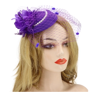 Detailed close-up of purple mesh fascinator hat with elegant feather flower and pearl accents