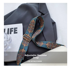 Detail of adjustable wide shoulder strap with vintage geometric pattern and gold buckle