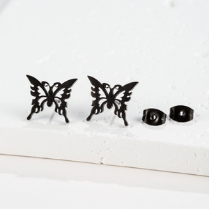 Macro view of matte black stainless steel butterfly studs with detailed cutout patterns