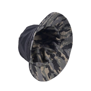 Detail of reversible bucket hat showing woodland camouflage pattern and plain dark fabric