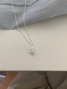 Macro detail of natural freshwater pearl pendant with irregular silver streamlining