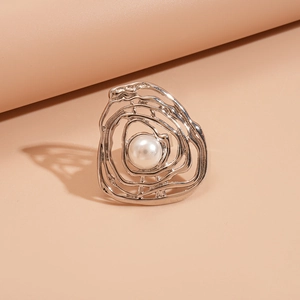 Macro shot of silver irregular layered lines on a textured ring with white pearl detail