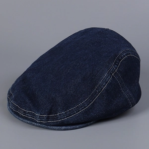 Detail of dark blue denim flat cap featuring classic contrast stitching and vintage wash