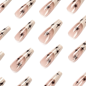 Long ballet press-on nails with nude pink base, black french tips and starburst patterns