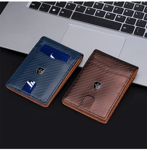 Slim men's RFID carbon fiber wallet in navy and dark brown colors on laptop keyboard