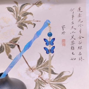 Dettaglio di forcina per capelli blu in acetato con nappe a farfalla e pergamena antica