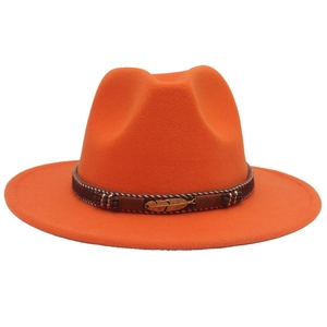 Detail of orange wide brim fedora hat featuring ethnic band and golden feather ornament