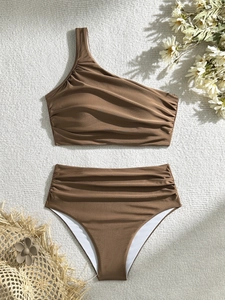 Elegant chocolate brown one shoulder bikini set with high waisted ruched bottoms on a rug