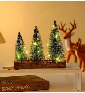 Close-up of three mini LED lit Christmas trees on a rustic wooden base for table decoration