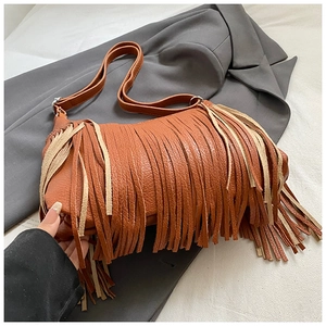 Macro shot of brown faux leather texture and multi-layer tassels on a crossbody bag