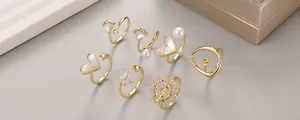 Dettaglio del set di anelli placcati in oro 14K con perle, farfalle e zirconi lucidi