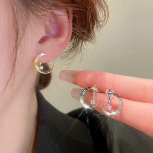 Detailed macro view of celestial moon and star stud earrings with sparkling zircon stones