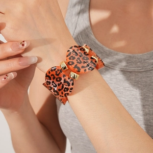 Close-up of leopard resin bracelet with gold hardware and natural shadow accents
