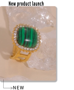 Macro detail of gold square malachite ring with sparkling zircon border on white background