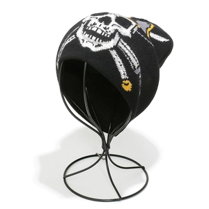 Detail of black knitted beanie featuring white skull and crossbones jacquard pattern