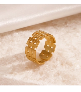 Macro detail of gold-plated open ring featuring a geometric hollow lattice design