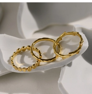 Macro detail of three-piece 18K gold plated stackable rings with textured honeycomb patterns