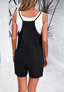 Rear view of a black woven jumpsuit for women shown in a natural outdoor setting
