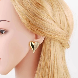 Elegant 18k gold heart earrings with mixed polished and matte finish shown on model