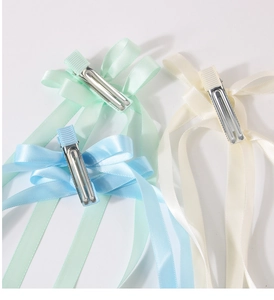 Detailed back view of satin bow hair clips showing silver metal alligator clips in three colors