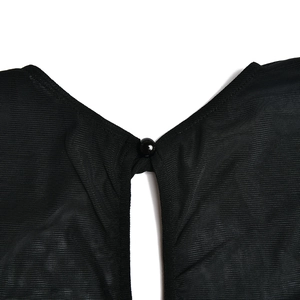 Detail des schwarzen Netzkleidausschnitts mit rundem Knopf und transparenter Textur