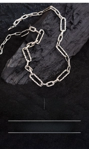 Detail view of silver plated paperclip chain necklace with 46cm length on black sand
