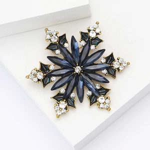 Elegant snowflake brooch with deep blue crystals and rhinestones on gold setting