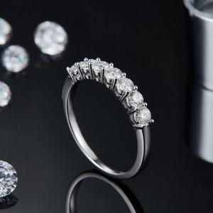 925 sterling silver seven-stone moissanite ring with premium round cut gems on black surface