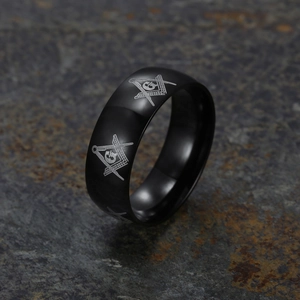 Black stainless steel Freemasonry ring with letter G and compass symbol on stone background