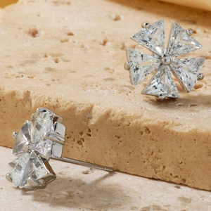 Sparkling silver flower stud earrings with transparent zircon inlay shown on stone