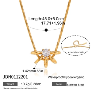 Détails d'un collier chaîne serpent en acier doré avec un pendentif en cristal rond