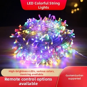 Close-up of RGB LED string lights with vibrant multi-color glow on a dark wooden base