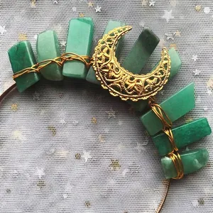 Detailed macro of gold moon crown with hand-wrapped green crystals and crescent moon