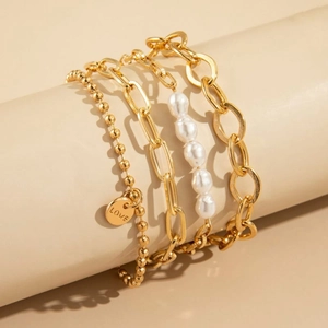 Golden multi-layer bracelet set with LOVE pendant and pearls on cylindrical display