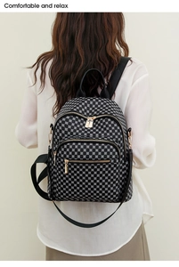 Detailed view of women's backpack with geometric print and golden metal zippers