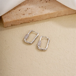 Elegant silver U-shaped rectangular earrings with cubic zirconia on a beige backdrop