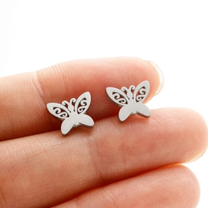 Macro shot of silver hollow butterfly stud earrings in polished stainless steel