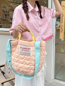Quilted heart peach tote bag with light blue shoulder strap shown in a lifestyle setting