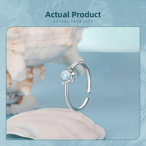 Macro shot of S925 sterling silver turtle ring with blue larimar stone on a shell