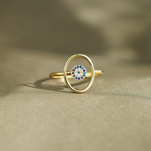 Macro shot of gold S925 silver evil eye ring with blue and white inlaid gemstones