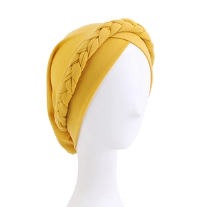Close-up of bright yellow braided headwrap with soft knitted texture on mannequin