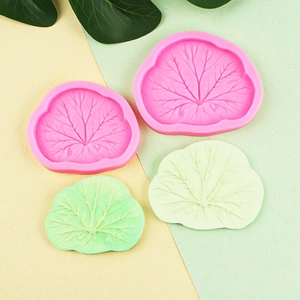 Pink silicone leaf vein molds with green and white fondant leaf samples on bicolored background