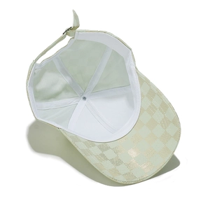 Detail of light green baseball cap with gold checkerboard print and buckle strap