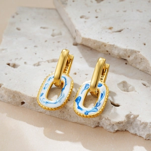 Detailed macro view of S925 blue and white enamel gold-plated porcelain drop earrings