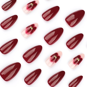 Faux ongles amande brillants bordeaux avec motifs floraux et accents de perles dorées