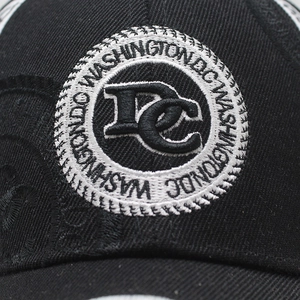 Macro detail of the Washington DC circular embroidery on black cotton baseball cap